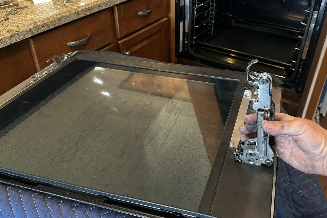 A built-in oven opening seen from the front with the appliance door lying on a blanket in the foreground
